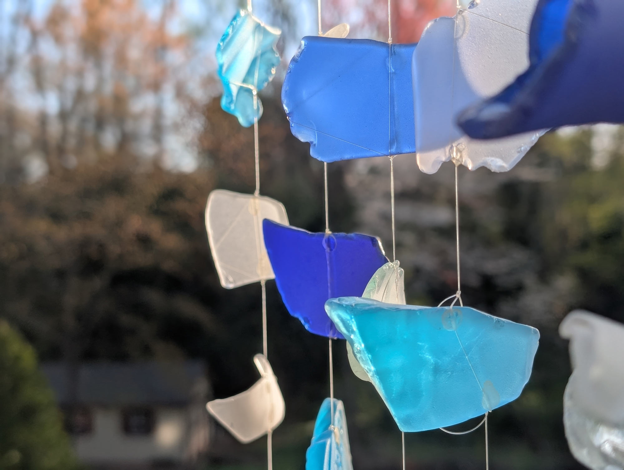 Close up of a blue and white sea glass wind chime