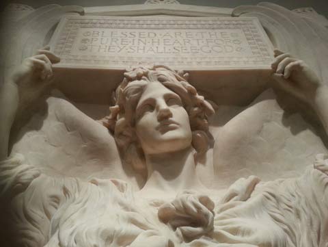 Photo of a marble sculpture of a woman who appears angelic