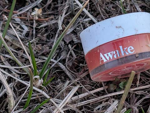 A small rose colored bottle of make up with the word 