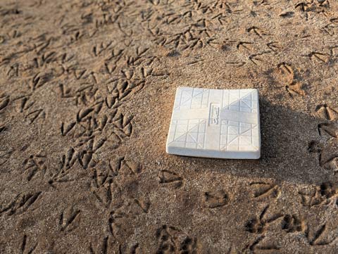 Second base and the surrounding dirt covered in geese tracks