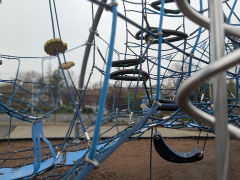 A tangle of cables, ropes, nets, tires and other parts of a piece of playground equipment