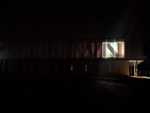 An upper case letter N glowing in the darkness