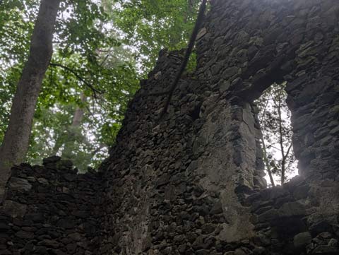 A hole for a window ih the stone wall of an old ruined house