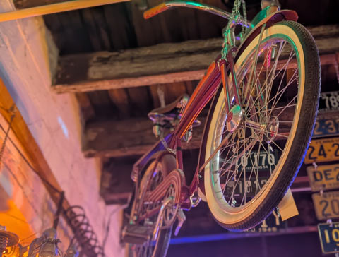 A vintage bicycle hang from exposed rafters